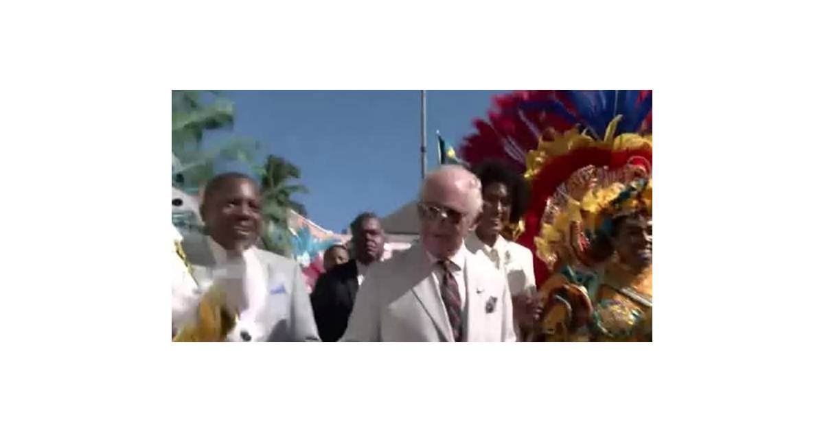 Britain's King Charles dances with revelers in a Bahamas street parade